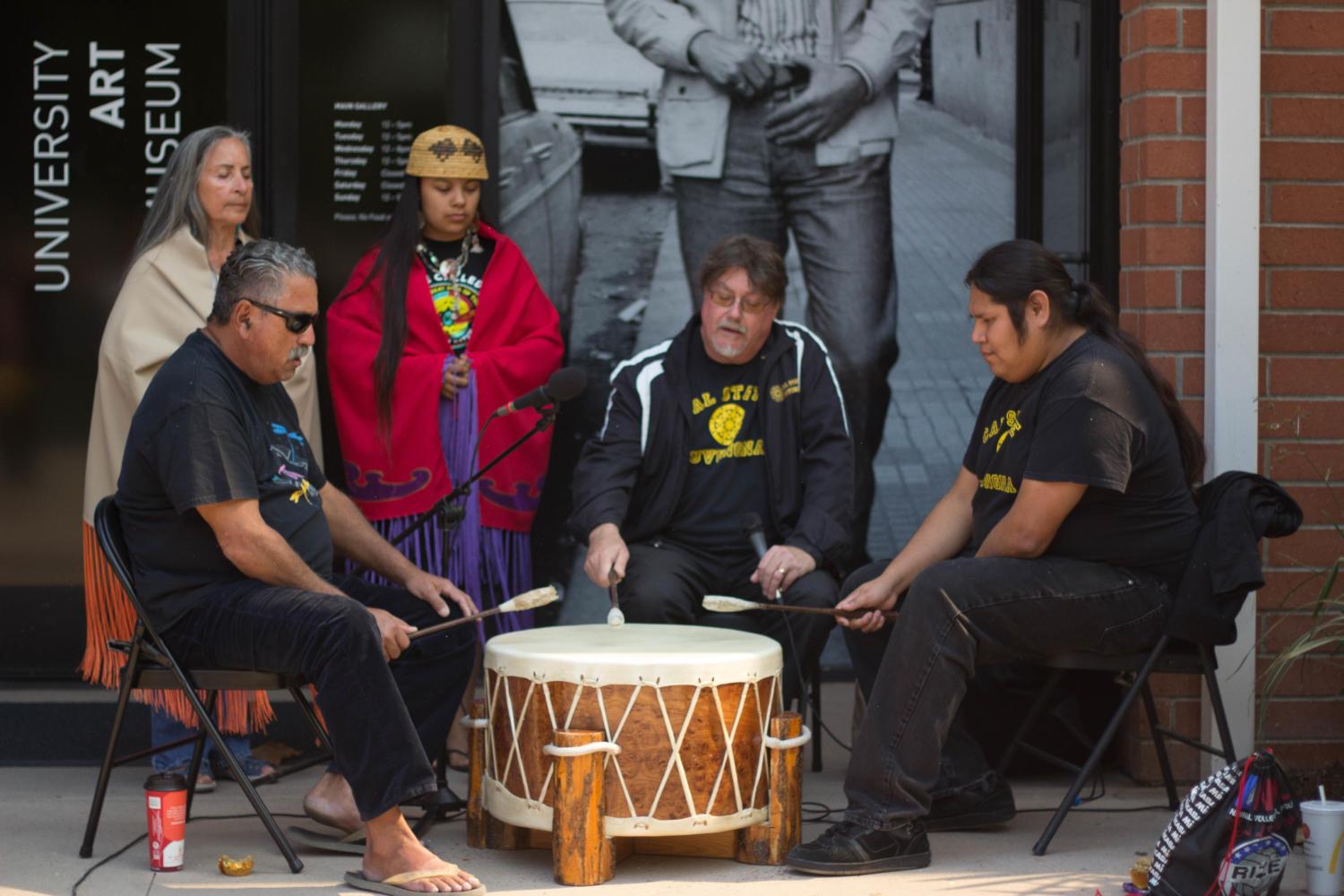 A group of indiginous activists perform in a drum circle.