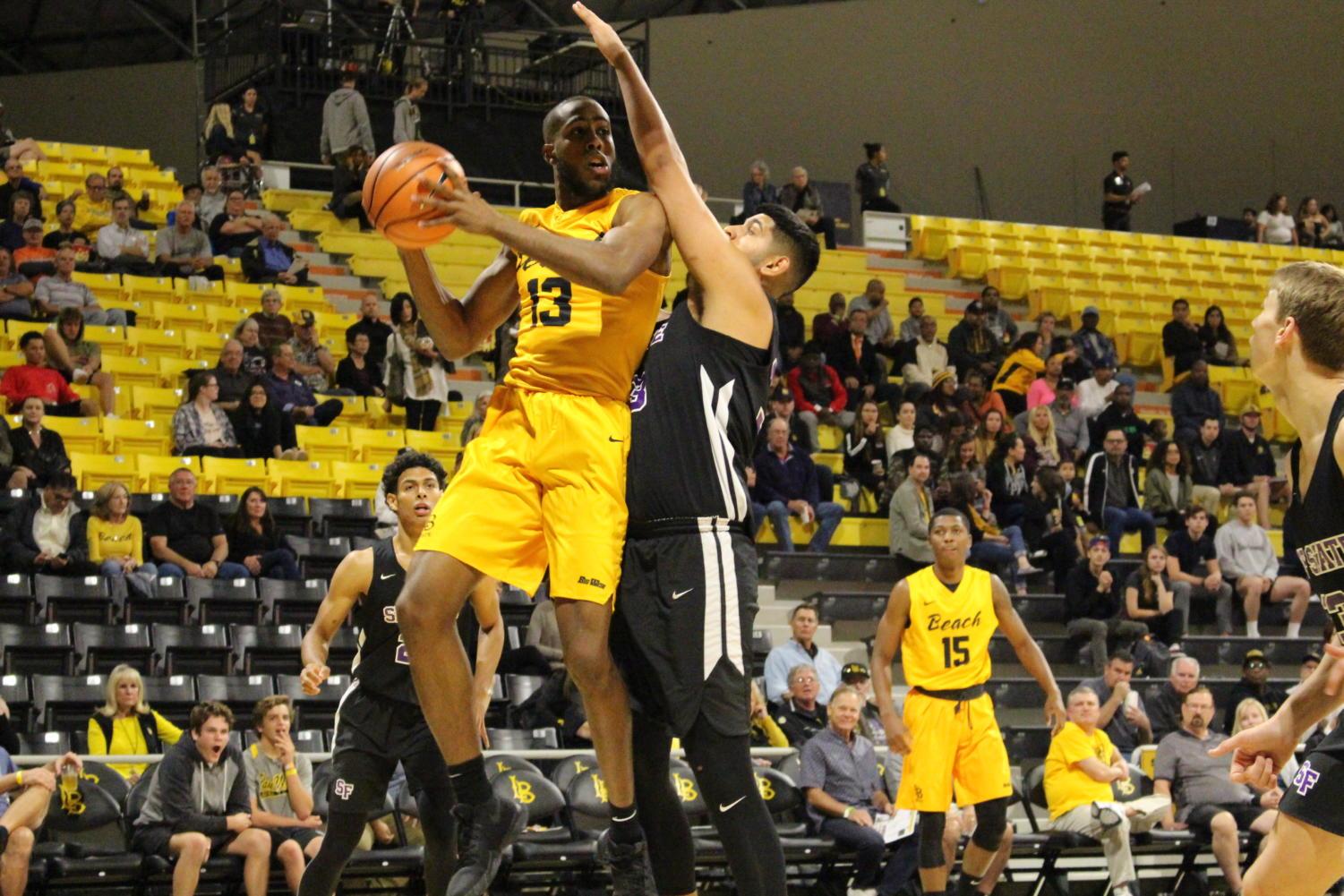Long Beach State senior forward Barry Ogalue looks to pass the ball while he is under the basket in Tuesday's game against San Francisco State at the Walter Pyramid.