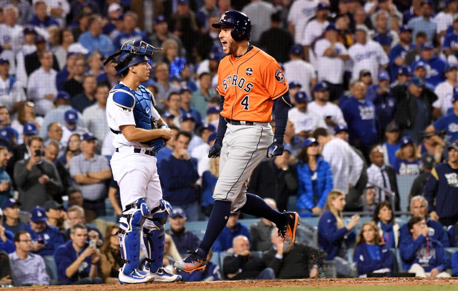 The Houston Astros' George Springer (4) celebrates his two-run home run in front of Los Angeles Dodgers catcher Austin Barnes in the second inning during Game 7 of the World Series at Dodger Stadium in Los Angeles on Wednesday, Nov. 1, 2017.