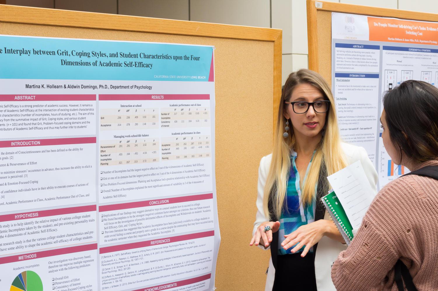 Graduate psychology student Martina Hollearn presents her research project to another student. The research competition was one of many events hosted during the 46th Annual Psych Day.