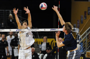 Volleyball player going up for a block.