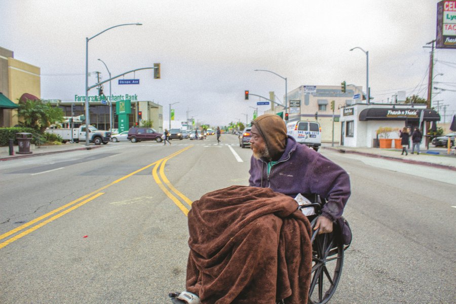 Un hombre en silla de ruedas cruza la calle.