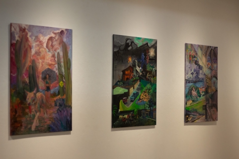 Three paintings hanging on the wall of the art gallery