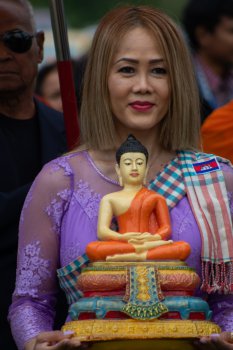 Woman holds a Buddha statue.