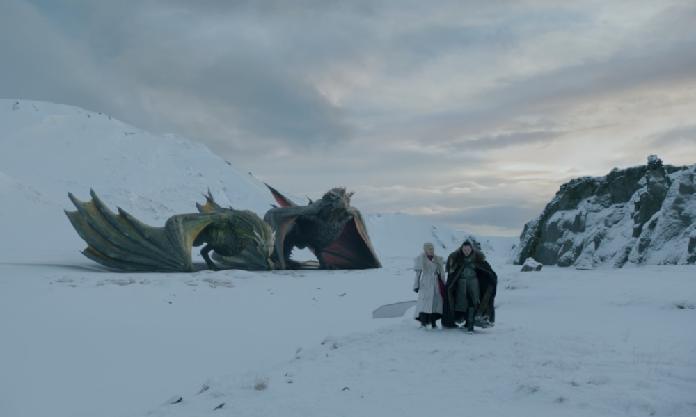 Two dragons sit in the snow behind Jon Snow and Daenerys Targaryen.