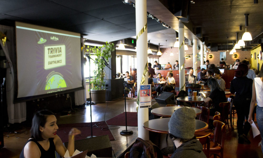 Students sit in The Nugget in front of a screen that says "Trivia Tournament for Earthlings"
