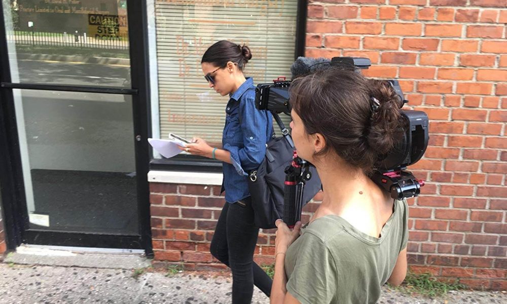 A camera woman follows Congresswoman Alexandria Ocasio Cortez down the street