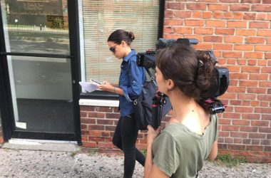 A camera woman follows Congresswoman Alexandria Ocasio Cortez down the street