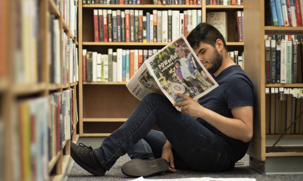 LBSU student Carlos Villicana reads the Daily 49er in the Ruth Bach Branch of the Long Beach Public Library