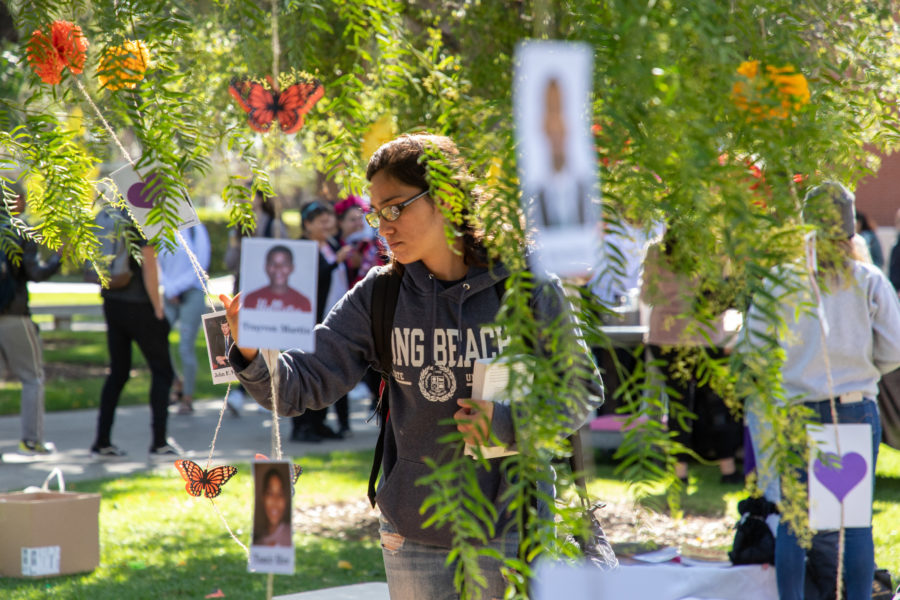 a student looking at the tree of life at the Dia De Los Muertos event