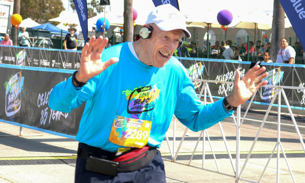 old man running across the finish line
