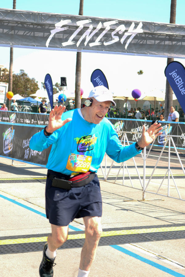 old man running across the finish line