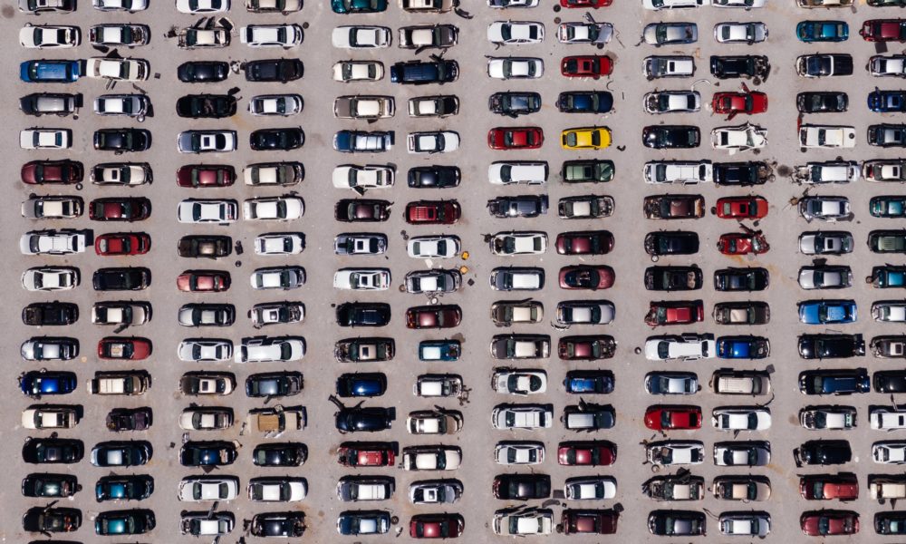 a photo illustration of a whole lot of cars in a parking lot. The point of view is from overhead.