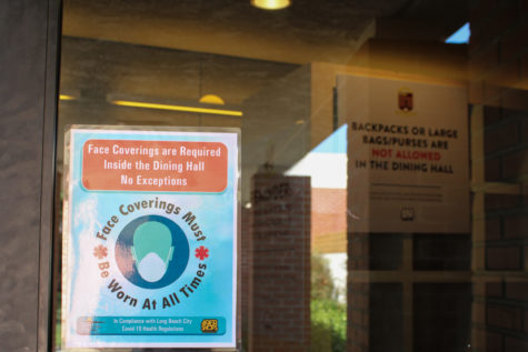 A sign in the window of the Parkside dormitory building warns those entering to wear a mask