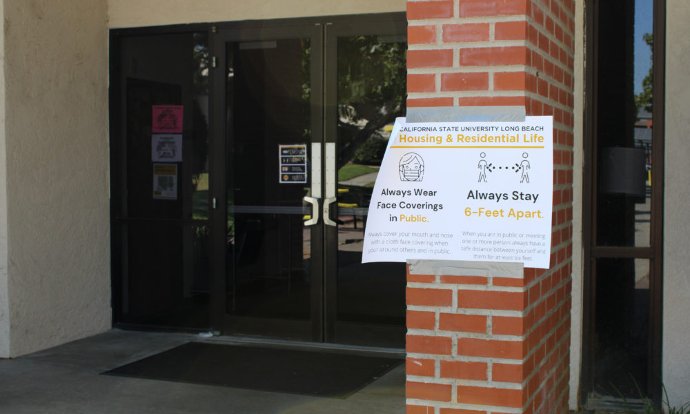 A sign on the front of the Parkside Dorms building tells passerbys and residents to always wear a mask and maintain social distancing