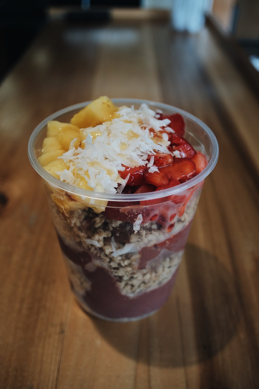 A photo of an açaí bowl topped with fruit and coconut shavings