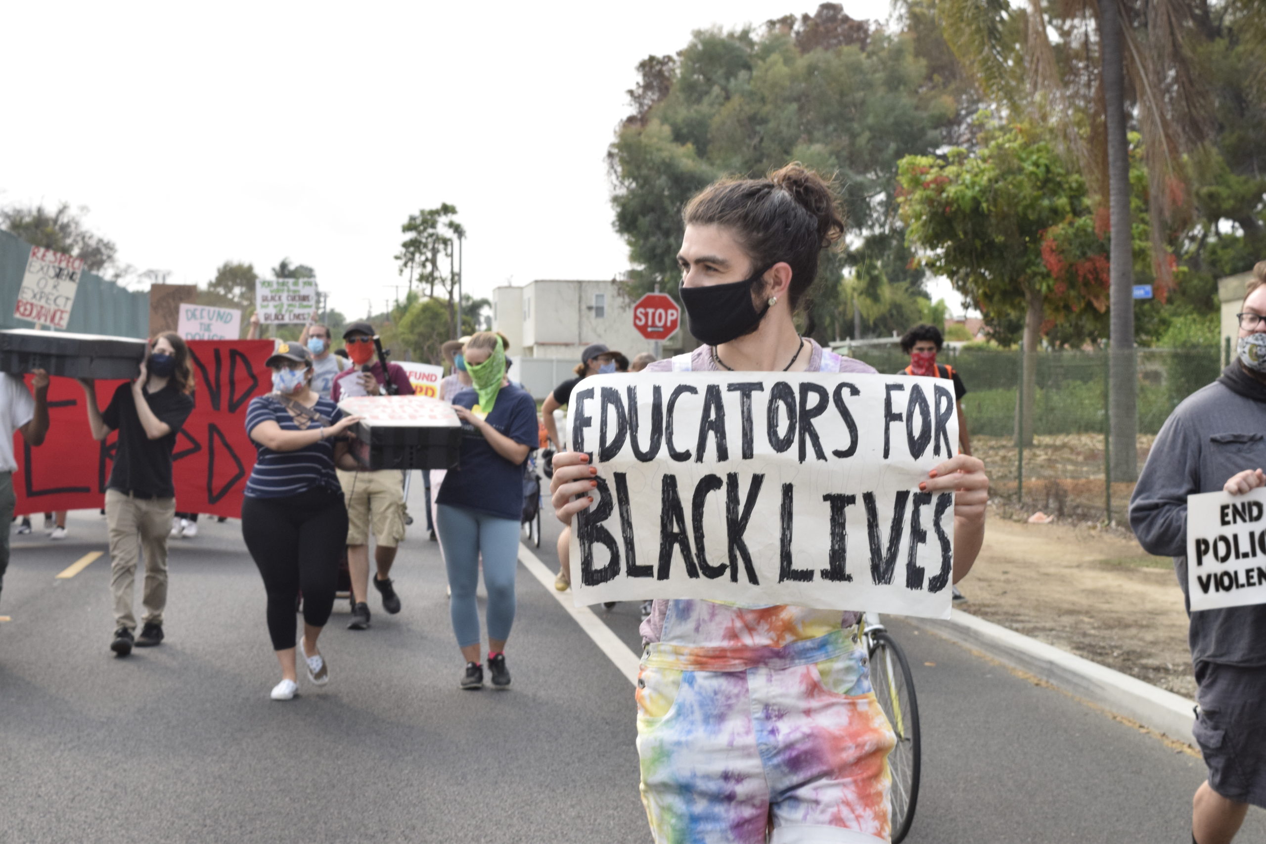 A man marches with a sign that reads "Educators for Black Lives"