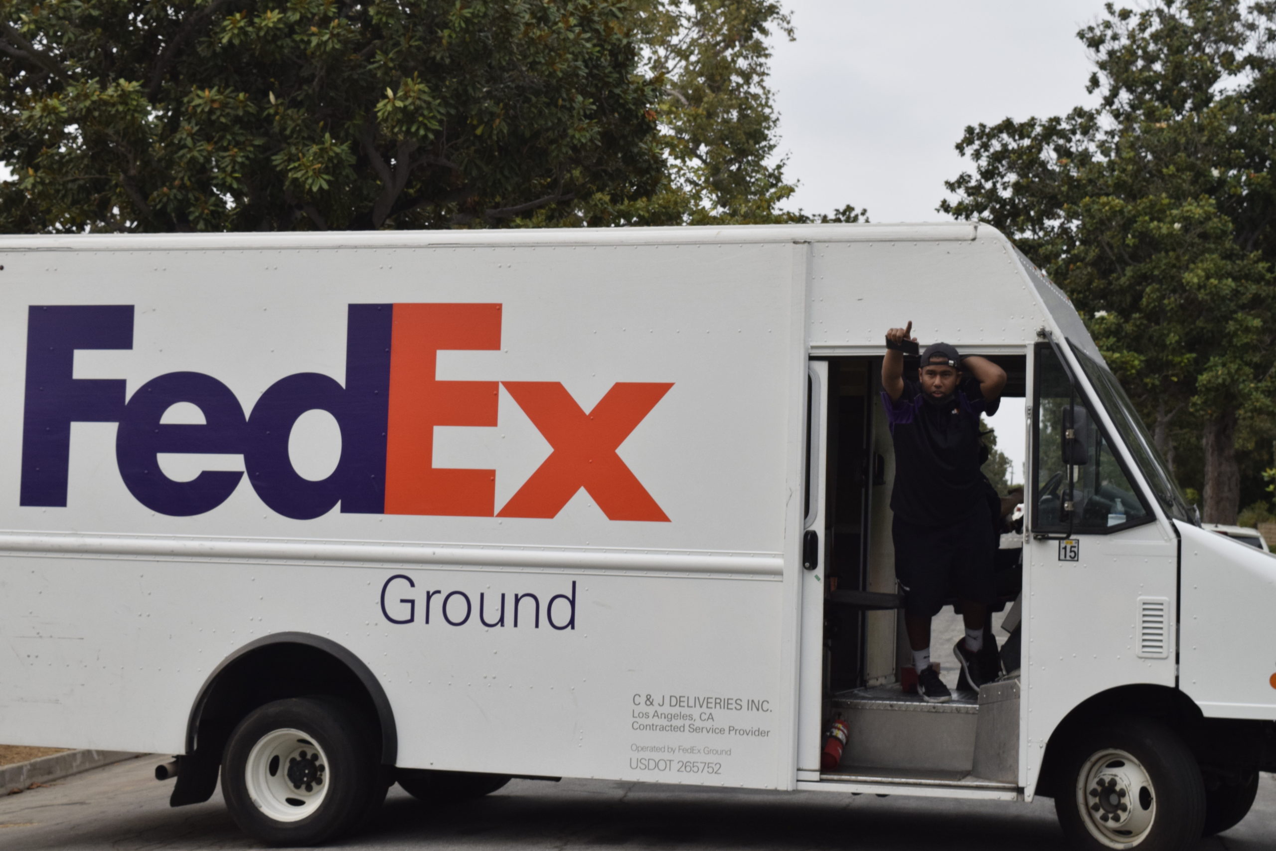 A FedEx driver gives a thumbs up