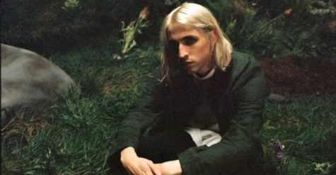 Musician Porter Robinson sits in the forrest