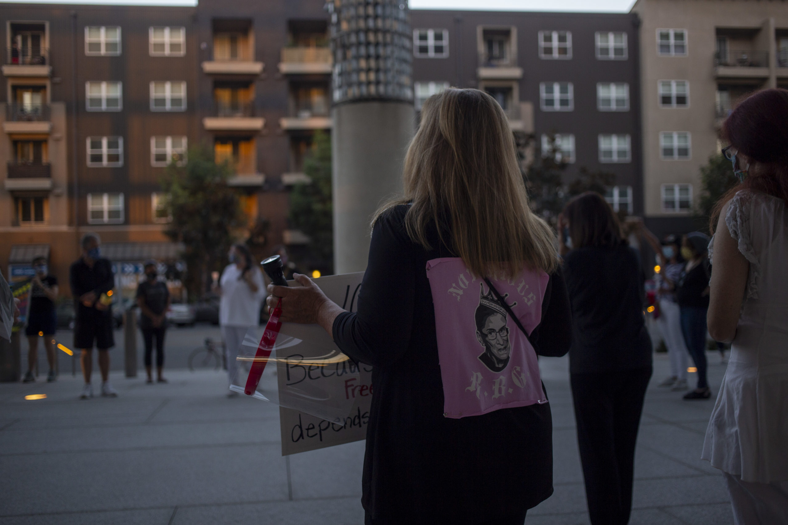 A woman stands with a photo of Ruth Bader Ginsburg on her back
