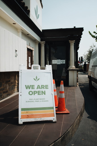 A sign that reads "we are open" outside Plant Power, vegan restaurant, in Long Beach
