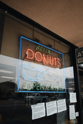 Electric sign that reads Fresh Donuts open 24 hours