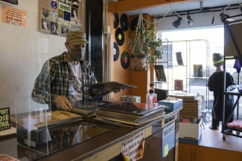 Gary Farley, owner of Third Eye Record shop, sorts through a new shipment of vinyls before opening.