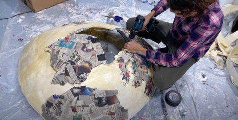 A screenshot from Ashley Steeves&squot; video "Behind the the Scenes - Prop making for Netflix &squot;We watched it all&squot; 2020" where she works on one portion of the paper mache planet Earth. Screenshot by Paris Barraza.