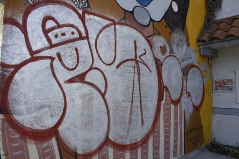 Graffiti signature covering POW WOW mural art is of "Pound Dog", a local Long Beach graffiti artist.