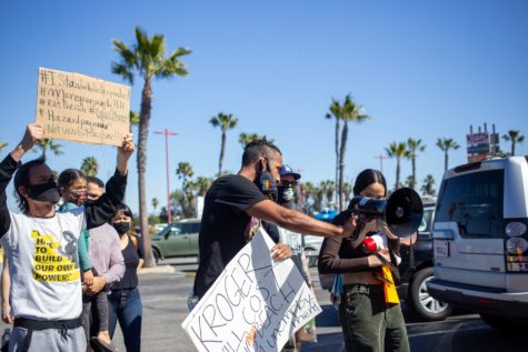 EJ Medal, left, Anthony Bryson, middle, and Rachel Osuna, right, march in the parking lot of a Ralphs location in Long Beach as part of Sunday's protest of Kroger Co. Julia Terbeche/ Daily Forty-Niner