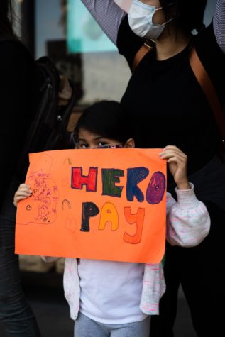 Luna Estrada, age 6, holds her sign with her mother, Julia, during the calls to boycott Kroger Co stores in Long Beach.