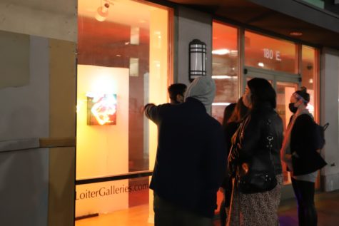 Different crowds of onlookers viewed through the storefront windows of the Loiter Galleries during the opening night of the exhibit.