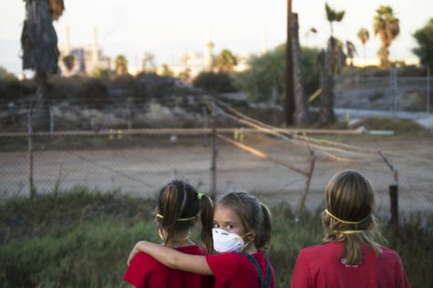While three little girls gazed upon a failed desalination plant and it&squot;s smog-filled background in a 2016 image entitled "Future Now," Estrada unknowingly predicted the reality of 2020 and the facemask.