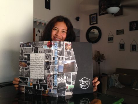 Ashley Ramos poses with her yearbook senior year that she oversaw the production of.