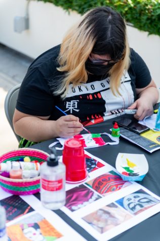 Christine Llacsa, 23, English major, is painting a hybrid flag composed of the Mexican and Peru flags to pay homage to her heritage and her parents immigrating to the US.