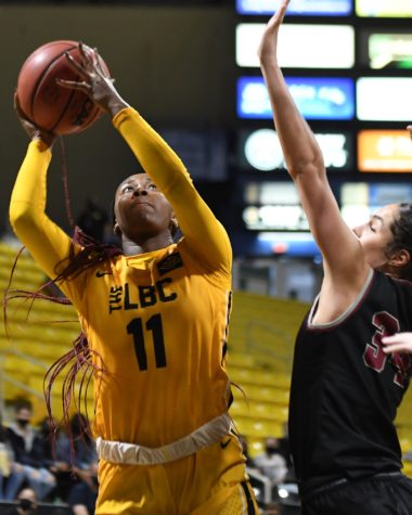 Featured is LBSU Guard Jasmine Hardy driving the ball in against a defender.