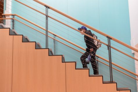 A student walking up the stairs at the Student Success Center.