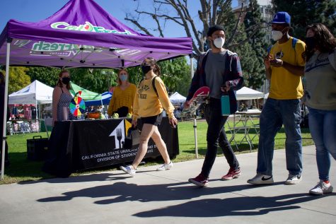 Students walk past the Cal Fresh Healthy Living table during the CSULB Week of Welcome.
