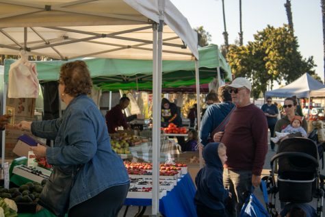 People buy produce at a Local Harvest farmers market at Marine Stadium