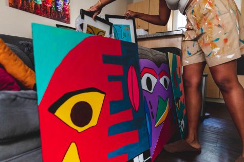 Artist, Tomisin Uwuole goes through her collection of work inside of her home in Long Beach.