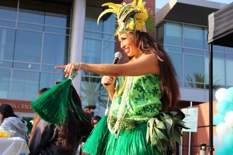 Performer gets crowd to participate in a Hula dancing lesson.