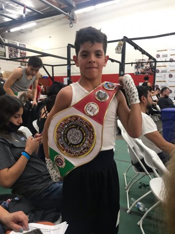 Ben Valenzuela receiving a belt after winning a fight.