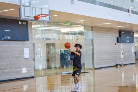 A student practices basketball at the Student Wellness and Recreation Center.
