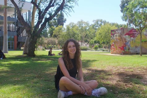 Samantha Soto sitting on the lawn near the Vivian Engineering