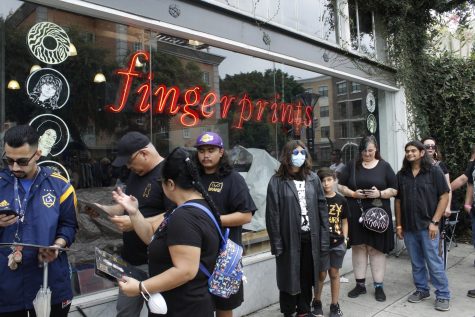 Fans wait outside Fingerprints Music to get their records signed by Ozzy Osbourne.