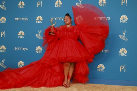 Lizzo poses with her first Emmy in the press room after winning award.