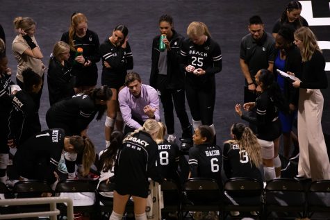 10/29/2022: Long Beach, CA- LBSU women's volleyball head coach Tyler Hildebrand talks with his team during a timeout, during the team's five set win against Cal Poly on Saturday.