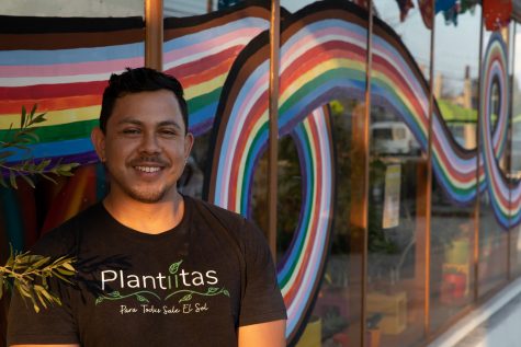 10/6/2022: Long Beach, CA- Kevin Alcaraz co-owner of Plantitas Plant Shop smiles into the sunset on Retro Row in Long Beach on Thursday, while the rainbow swirls behind them.