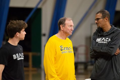 Long Beach State Men's basketball head coach, Dan Monson (left), alongside assistant coach, Myke Scholl (right), plan out what they are going to do for the team's first practice of the season.