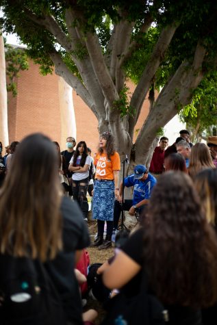 Sister Cindy preaches to a crowd of students who are gathered in a circle around her. She&squot;s wearing a shirt that reads "Ho No Mo."